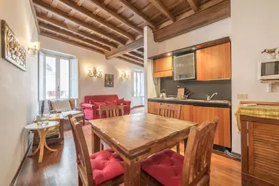 a kitchen and living room with a wooden table and chairs at Panetteria Apartment in Rome