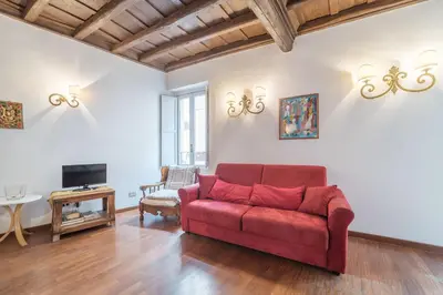 a living room with a red couch and a tv at Panetteria Apartment in Rome
