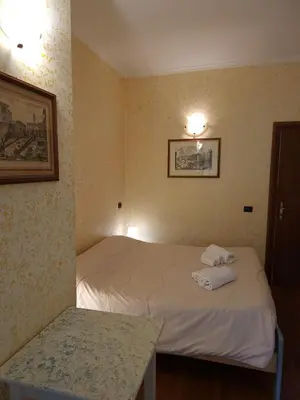 a hotel room with two beds and a table at St. Peter's Rooms Rome in Rome