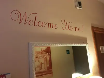 a welcome home sign above a mirror in a bathroom at Suites Trastevere in Rome
