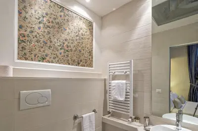 a bathroom with a sink and a painting on the wall at Little Queen Suite in Rome