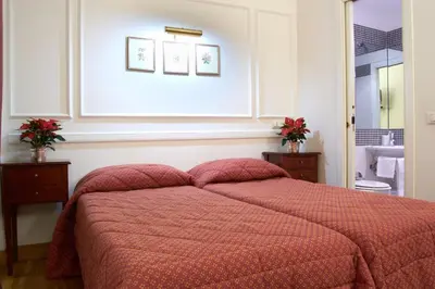 a bedroom with a bed with a red comforter at Domus Mazzini in Rome