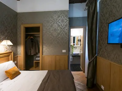 a bedroom with a bed and a tv on a wall at IG Suites in Rome