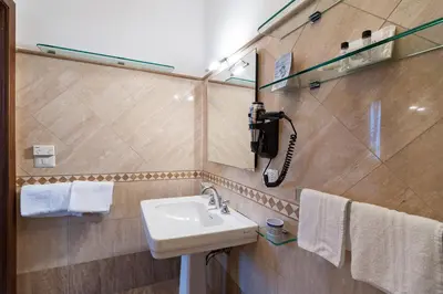 a bathroom with a sink and a phone on the wall at La Dolce Vita Barberini in Rome
