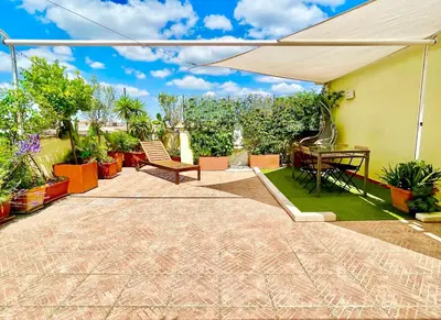 a patio with an umbrella and a table and chairs at Appartamento con magnifico terrazzo vicino a Metropolitana e Vaticano in Rome