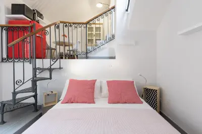a bedroom with a bed with two red pillows at Quiet pied a terre with terrace in Borgo Pio in Rome