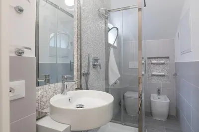 a white bathroom with a sink and a toilet at Quiet pied a terre with terrace in Borgo Pio in Rome