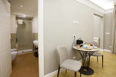 a bathroom with a table and chairs and a toilet at Ripetta 25 Prestige Rooms in Rome