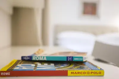 two books stacked on top of each other on a table at Ripetta 25 Prestige Rooms in Rome
