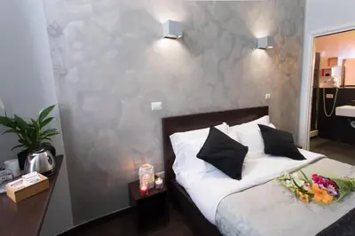 a bedroom with a bed with white sheets and black pillows at Chroma Italy - Chroma Pente in Rome