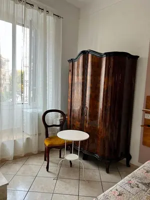 a table and a chair next to a wooden cabinet at In the Center by Local Domus in Rome