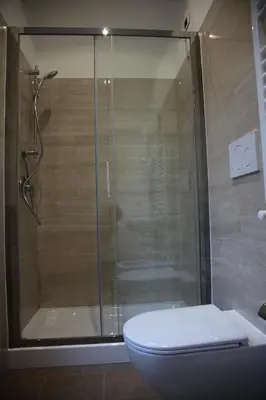 a bathroom with a glass shower with a toilet at Federica's Home in Rome