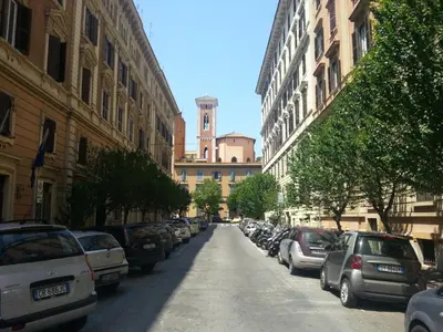 a city street with parked cars and a clock tower at Vatican Town in Rome