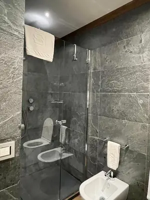 a bathroom with a shower and a toilet and a sink at Villa Spalletti Trivelli - Small Luxury Hotels of the World in Rome