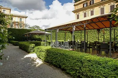 a table and chairs under a pavilion in a garden at Villa Spalletti Trivelli - Small Luxury Hotels of the World in Rome