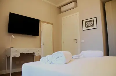 a bedroom with two beds and a flat screen tv at Nomentana House in Rome