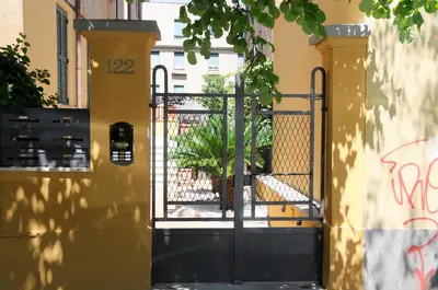 a gate to a building with graffiti on it at Nomentana House in Rome