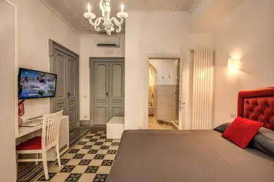 a bedroom with a bed and a table and a desk at Feronia Guest house in Rome
