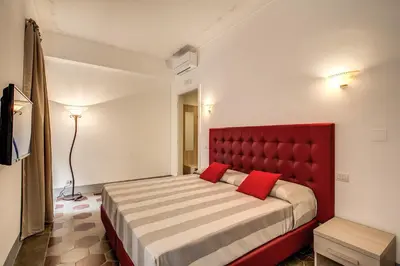 a bedroom with a large bed with a red headboard at Feronia Guest house in Rome