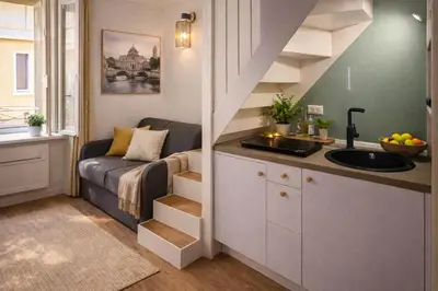 a small kitchen with a sink and a couch in a room at Tolli Colosseo Apartment in Rome