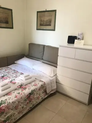 a small bedroom with a bed and a dresser at Asher's House Colosseum in Rome