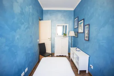 a blue bedroom with two beds and a desk at Stradivari Luxury Apartment in Rome