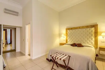a bedroom with a bed and a chair in it at Caput Mundi Suite in Rome