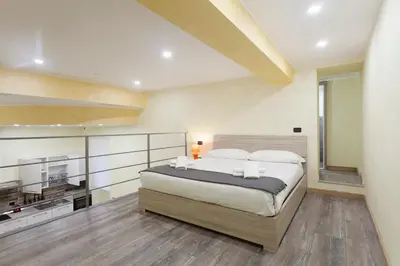 a bedroom with a large bed and a kitchen at Trastevere Charming Loft in Rome
