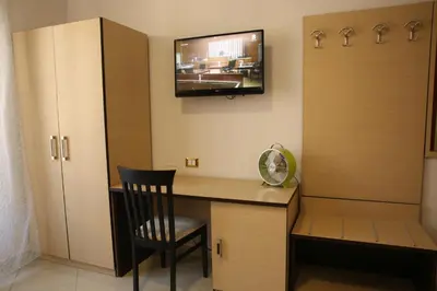 a room with a desk with a chair and a tv on the wall at All Seasons in Rome