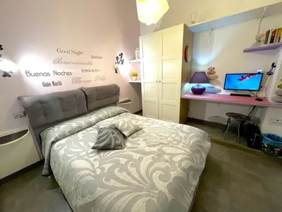 a bedroom with a bed and a desk with a laptop at Rhome86 in Rome