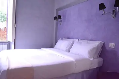 a white bed with white pillows in a bedroom at Tiburtina House in Rome