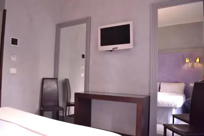 a bedroom with a white bed with a purple wall at Tiburtina House in Rome