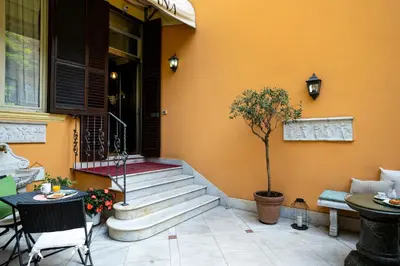 a porch with stairs and a table and a tree at Domus Pinciana in Rome