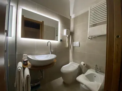 a bathroom with a sink and a toilet and a mirror at Condotti Rooms in Rome