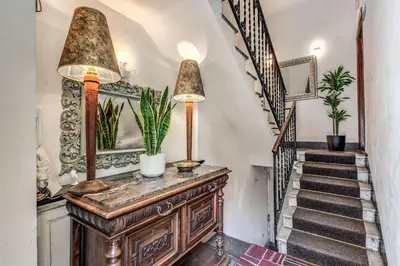 aoyer with a staircase and a wooden dresser with potted plants at Imperia Suite in Rome