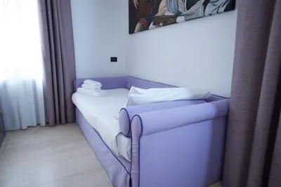 a purple couch in a room with a window at St. Peter' Six Rooms & Suites in Rome