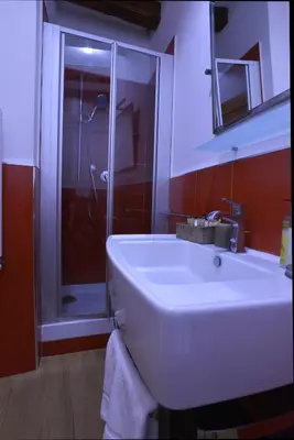 a bathroom with a white sink and a shower at St. Peter' Six Rooms & Suites in Rome