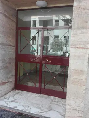 a red door with glass panels on a building at Liudan&rooms Affittacamere in Rome