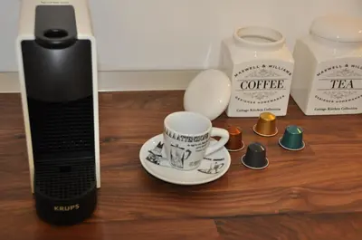 a table with a coffee cup on aucer next to a coffee maker at Appart. delizioso nel centro di Roma Vaticano in Rome