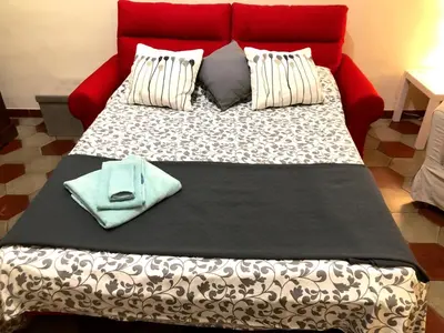 a large bed with a red headboard and pillows at Appart. delizioso nel centro di Roma Vaticano in Rome