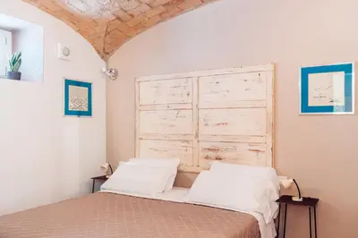a bedroom with a bed with a wooden headboard at Restart Accommodations Rosa in Rome