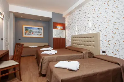 a hotel room with two beds and a table at Bed & Breakfast Armonie Romane in Rome