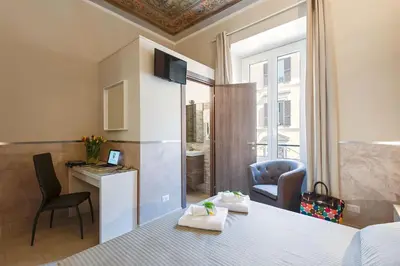 a room with a bed and a desk and a chair at Suite Horti Sallustiani in Rome