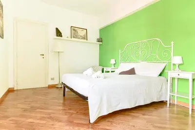 a bedroom with a white bed with a green wall at La Canterina al Vaticano in Rome