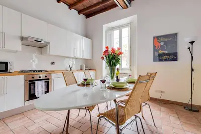 a kitchen with a white table and chairs in a room at Domus Florea in Rome