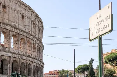 a street sign in front of the coliseum at The Dream Of Colosseum in Rome