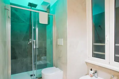 a bathroom with a glass shower and a toilet at The Dream Of Colosseum in Rome