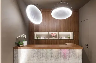 a lobby with two lights and a counter with flowers at A World Aparts - Barberini Boutique Hotel in Rome