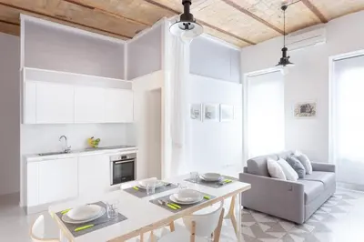 a kitchen and living room with a table and a couch at Lilli Vatican White Domus in Rome