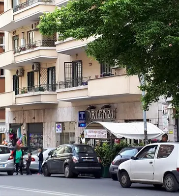 a street with cars parked in front of a building at A casa di Robi in Rome